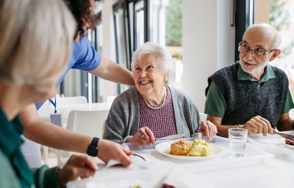 Caregiver Serving Lunch Caregiver Serving Lunch to Elderly Residents in a Care Home