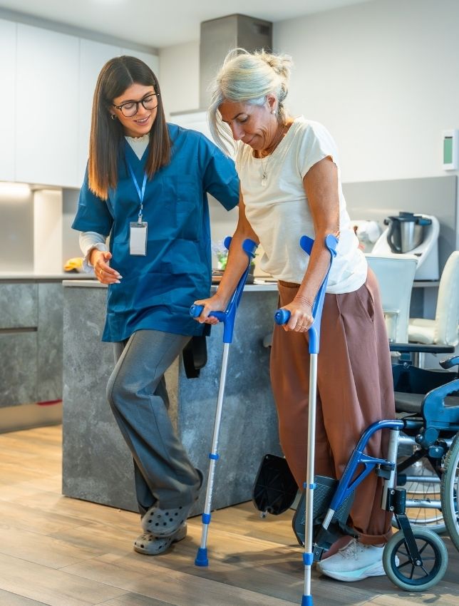 Caregiver assisting elderly woman Caregiver assisting elderly woman during physical at home